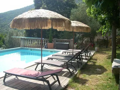 three lounge chairs and an umbrella next to a swimming pool at CHAMBRE INDEPENDANTE climatisée, cuisine d'été, piscine in Sartène
