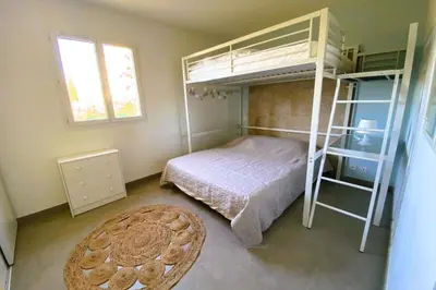 a bedroom with a bunk bed and a rug at Appartement Lena 6 pers piscine 500 m plage in Sainte-Lucie de Porto-Vecchio
