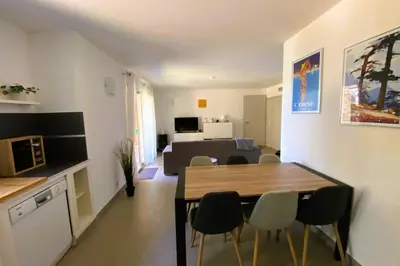 a kitchen and living room with a table and chairs at Appartement Lena 6 pers piscine 500 m plage in Sainte-Lucie de Porto-Vecchio