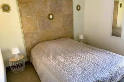 a small bedroom with a bed and two lamps at Appartement Lena 6 pers piscine 500 m plage in Sainte-Lucie de Porto-Vecchio
