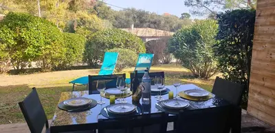 a table with plates and wine glasses on it at Appartement Lena 6 pers piscine 500 m plage in Sainte-Lucie de Porto-Vecchio