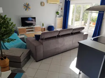 a living room with a couch and a tv at PALMA Piscine chauffée Grand jardin avec piscine à 1 km de la mer in Solaro