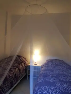 a bedroom with a bed and a table with a lamp at PALMA Piscine chauffée Grand jardin avec piscine à 1 km de la mer in Solaro