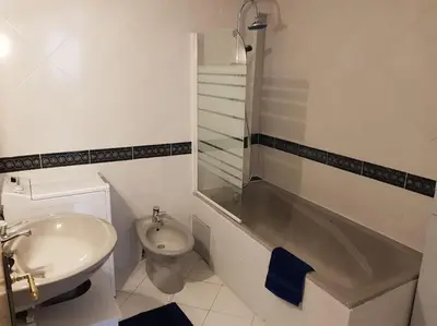 a white bathroom with a sink and a toilet at PALMA Piscine chauffée Grand jardin avec piscine à 1 km de la mer in Solaro