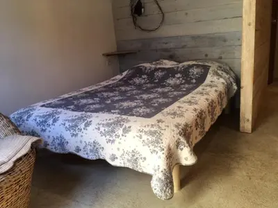 a bed with a black and white blanket on it at La rose bleue (2) in Olmeto