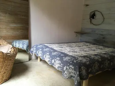 a room with two beds with a table in it at La rose bleue (2) in Olmeto