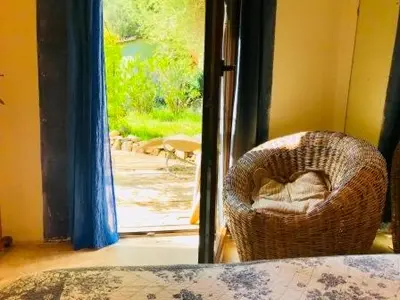 a wicker chair sitting in front of a door at La rose bleue (2) in Olmeto