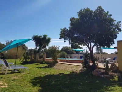 a park with a chair and an umbrella and a pool at OVU Piscine chauffée Entre mer et montagne à 1 km de la mer in Solaro
