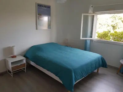 a bedroom with a blue bed and a window at OVU Piscine chauffée Entre mer et montagne à 1 km de la mer in Solaro
