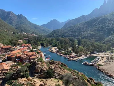 a town on a river with mountains in the background at Le cap’o in Porto Ota