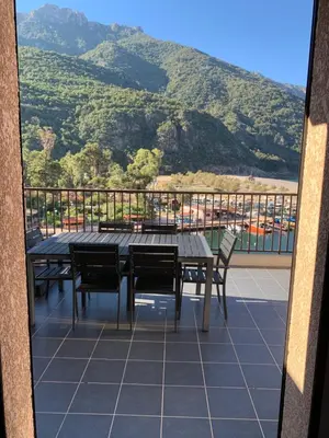 a table and chairs on a balcony with a view at Le cap’o in Porto Ota