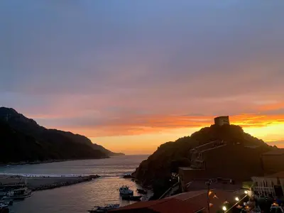 a sunset over a river with a castle on a hill at Le cap’o in Porto Ota