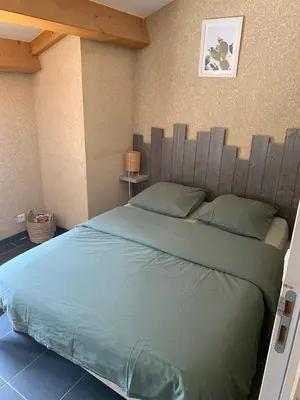 a bedroom with a large bed with a wooden headboard at Le cap’o in Porto Ota