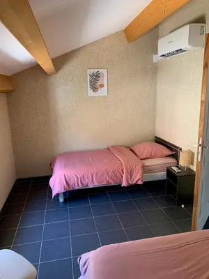 a bedroom with two beds with pink sheets at Le cap’o in Porto Ota