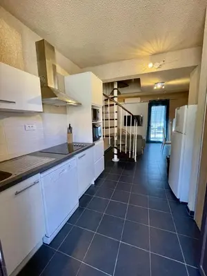 a kitchen with white appliances and a tile floor at Le cap’o in Porto Ota