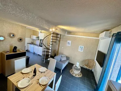 a room with a dining table and a living room at Le cap’o in Porto Ota