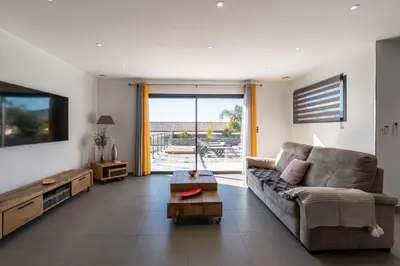 a living room with a couch and a tv at Afa proche Ajaccio, magnifique villa avec piscine privée 8 personnes in Afa