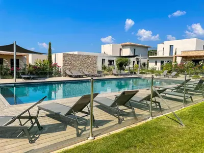 a swimming pool with lounge chairs next to a building at Villa MAYA in Lecci