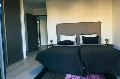 a bedroom with a large bed with black sheets and pillows at Villa MAYA in Lecci