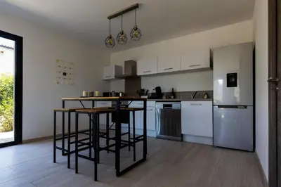 a kitchen with white cabinets and a black counter top at Villa MAYA in Lecci