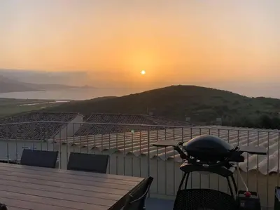a grill on a table with the sunset in the background at Panorama exceptionnel sur les hauteurs de Propriano in Propriano