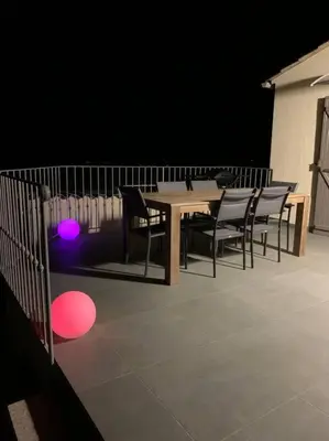 a table and chairs with lights on a stage at Panorama exceptionnel sur les hauteurs de Propriano in Propriano