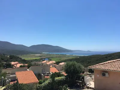 a town with houses and the ocean in the background at Panorama exceptionnel sur les hauteurs de Propriano in Propriano