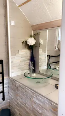 a bathroom counter with a sink and a vase of flowers at U Sognu 3128 in Muro