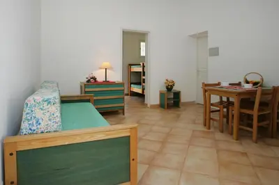 a room with a bed and a table and a dining room at Apartment by Lido Beach & Biguglia Lagoon in Borgo