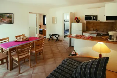 a living room and kitchen with a table and chairs at Apartment by Lido Beach & Biguglia Lagoon in Borgo