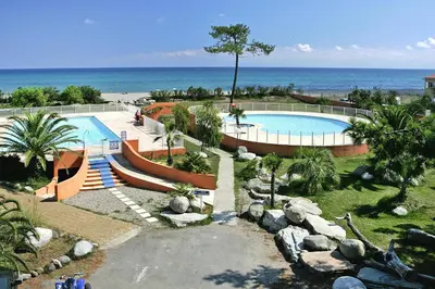 a large swimming pool with the ocean in the background at Apartment by Lido Beach & Biguglia Lagoon in Borgo