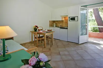 a kitchen and dining room with a table and a refrigerator at Apartment by Lido Beach & Biguglia Lagoon in Borgo