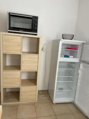 a kitchen with a microwave and a refrigerator at Appartement tout confort 2-4 pers 500 m de la plage avec piscine et wifi in Santa-Maria-Poggio