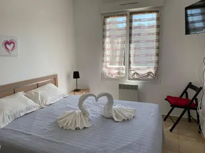 two swansrendered to be kissing on a bed at Appartement tout confort 2-4 pers 500 m de la plage avec piscine et wifi in Santa-Maria-Poggio