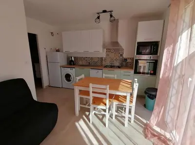 a kitchen with a table and chairs in a room at Grand studio classé 3 etoiles in Tavera