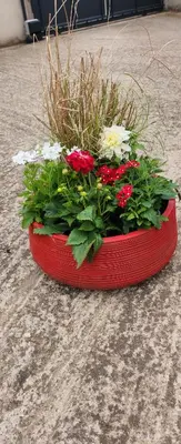 a red planter with flowers in it on the ground at Chambre d'hôtes Casa Lucia in Furiani