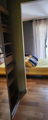 a room with a bedroom with a bed and a mirror at Chambre d'hôtes Casa Lucia in Furiani