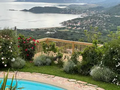 a pool in a garden with a view of the water at Petit coin de paradis, vue panoramique mer &montagne, piscine privée... in Calcatoggio