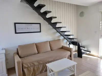 a living room with a couch and a staircase at Résidence Saint Florent Oletta in Saint-Florent
