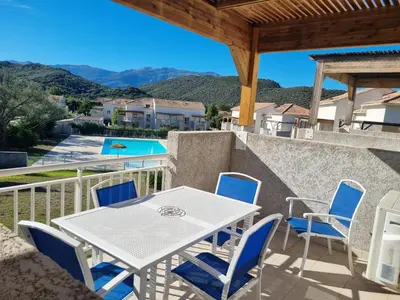 a patio with a table and chairs and a view at Résidence Saint Florent Oletta in Saint-Florent
