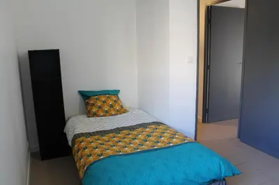 a bedroom with a bed with a blue comforter at Location Ajaccio in Ajaccio