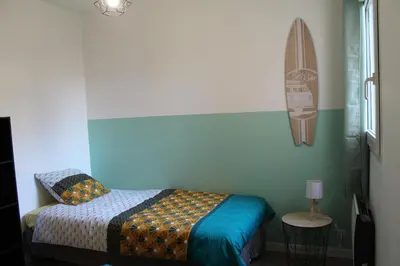 a bedroom with a bed and a surfboard on the wall at Location Ajaccio in Ajaccio