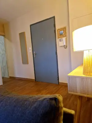 a room with a door with a couch and a lamp at Studio Climatisé Parking Gratuit in Sarrola-Carcopino