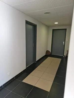 an empty room with two doors and a tile floor at Studio Climatisé Parking Gratuit in Sarrola-Carcopino
