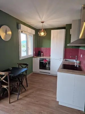 a kitchen with a table and a dining room at Studio Climatisé Parking Gratuit in Sarrola-Carcopino