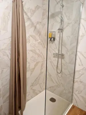 a shower in a bathroom with a glass door at Studio Climatisé Parking Gratuit in Sarrola-Carcopino