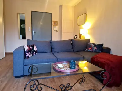a living room with a blue couch and a coffee table at Studio Climatisé Parking Gratuit in Sarrola-Carcopino