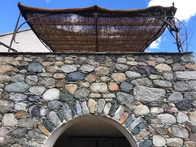 a table and chairs on a balcony with a view of mountains at Le CAPU BIANCU-LOCATION AVEC VUE PROCHE DES GORGES DE L ASCO ENTRE MER ET MONTAGNE in Moltifao
