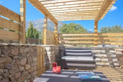 a bench sitting on a patio with a stone wall at Le CAPU BIANCU-LOCATION AVEC VUE PROCHE DES GORGES DE L ASCO ENTRE MER ET MONTAGNE in Moltifao