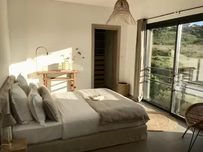 a bedroom with a large bed and a large window at 2 pièces vue mer à 3 min des plages in Propriano